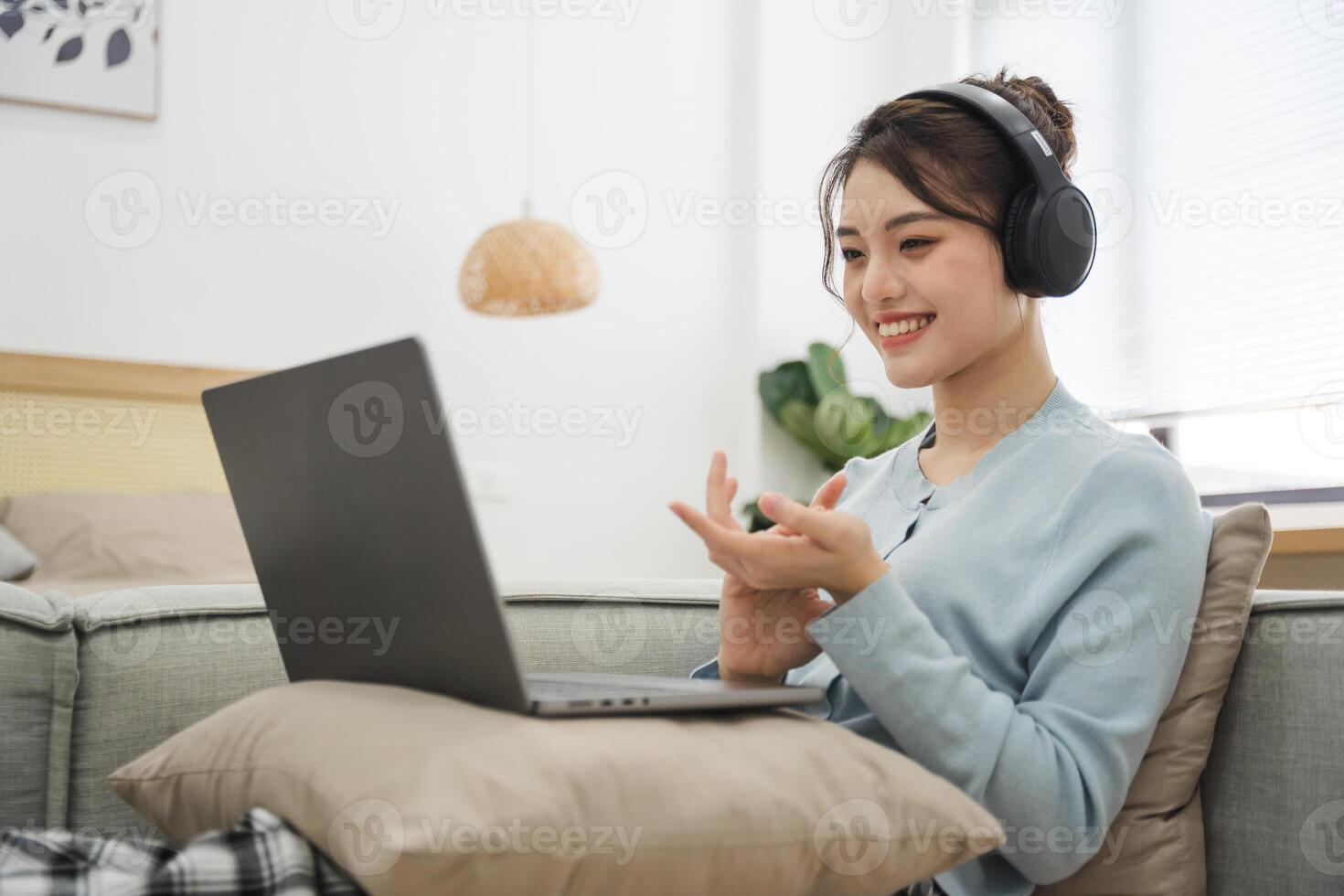 Portrait of Asian woman sitting on sofa at home photo