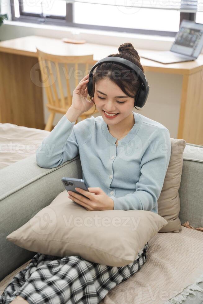 Portrait of Asian woman sitting on sofa at home photo