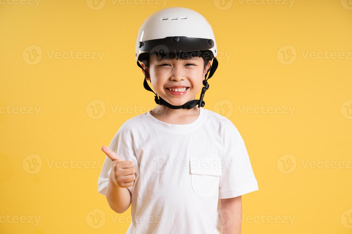 Portrait of adorable asian boy posing on yellow background photo
