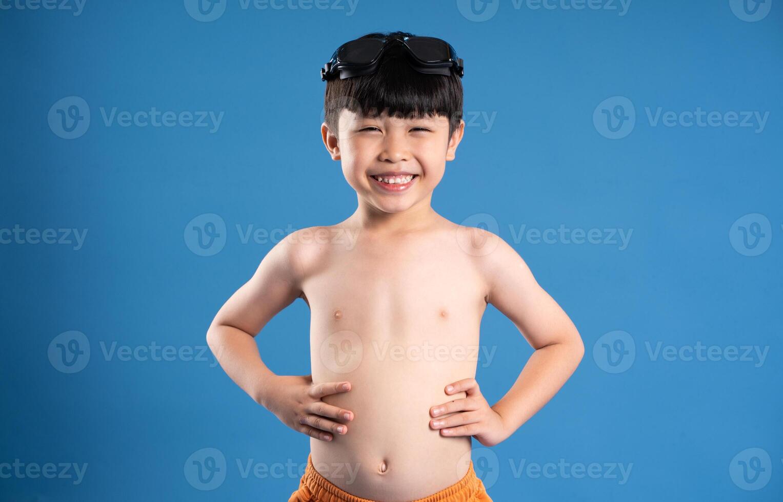 Portrait of asian boy posing on blue background photo