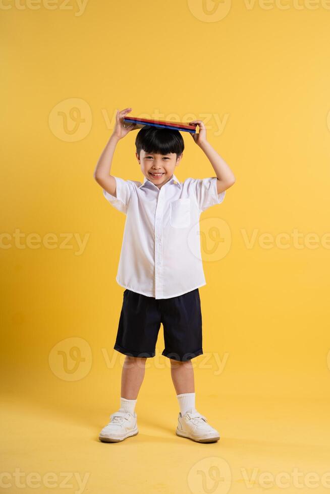 retrato de adorable asiático chico posando en amarillo antecedentes foto