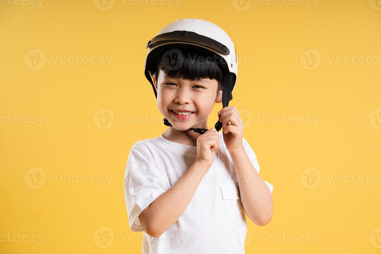 Portrait of adorable asian boy posing on yellow background photo