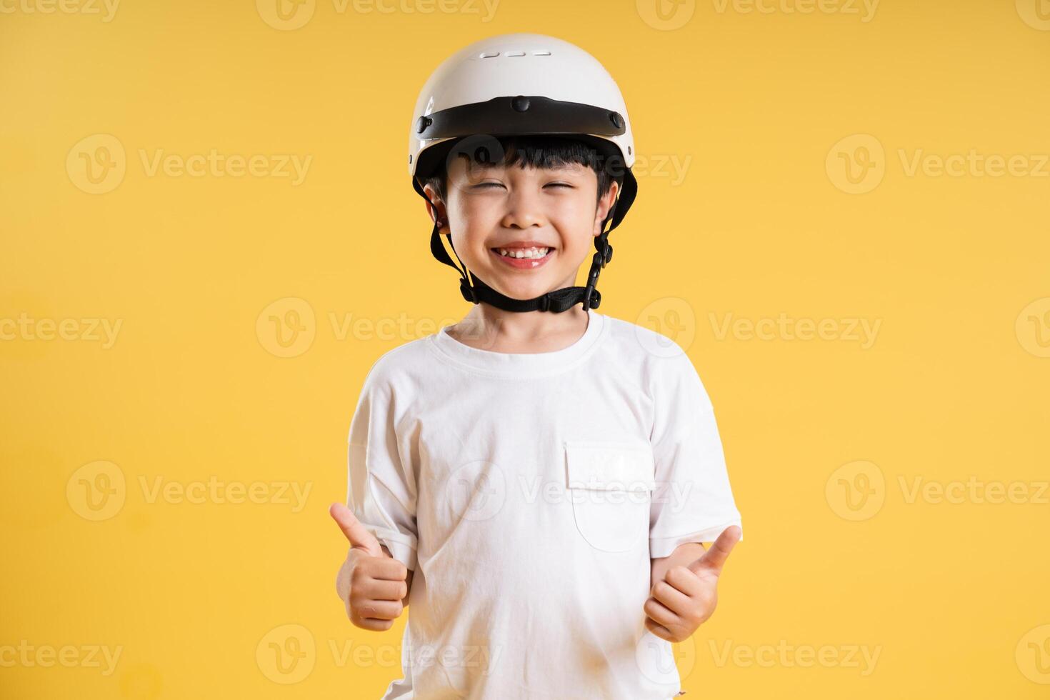 Portrait of adorable asian boy posing on yellow background photo