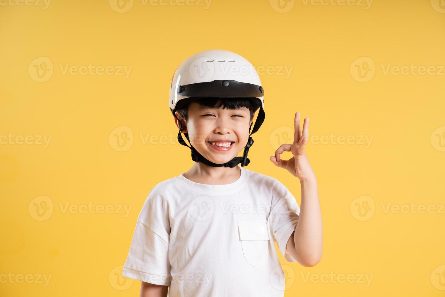 Portrait of adorable asian boy posing on yellow background photo