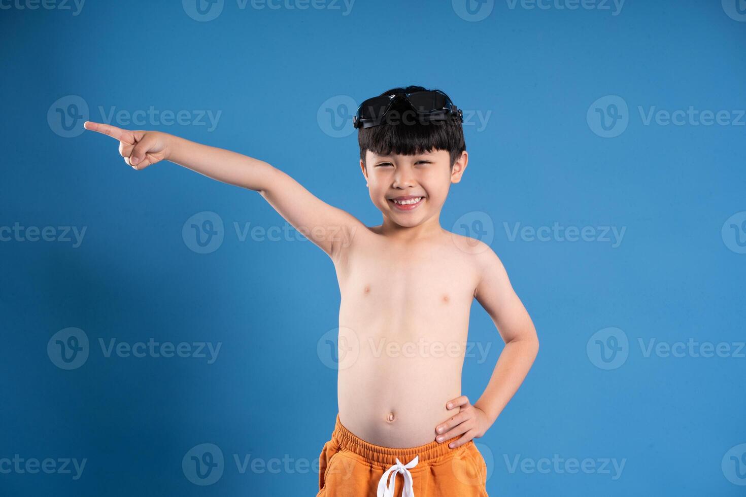 Portrait of asian boy posing on blue background photo