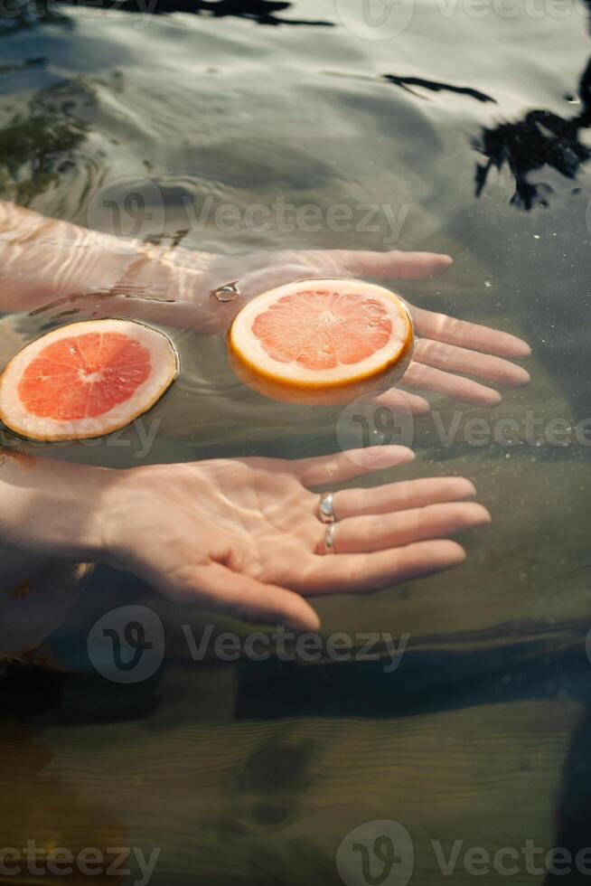 A hands splashes in a fragrant vat of citrus photo
