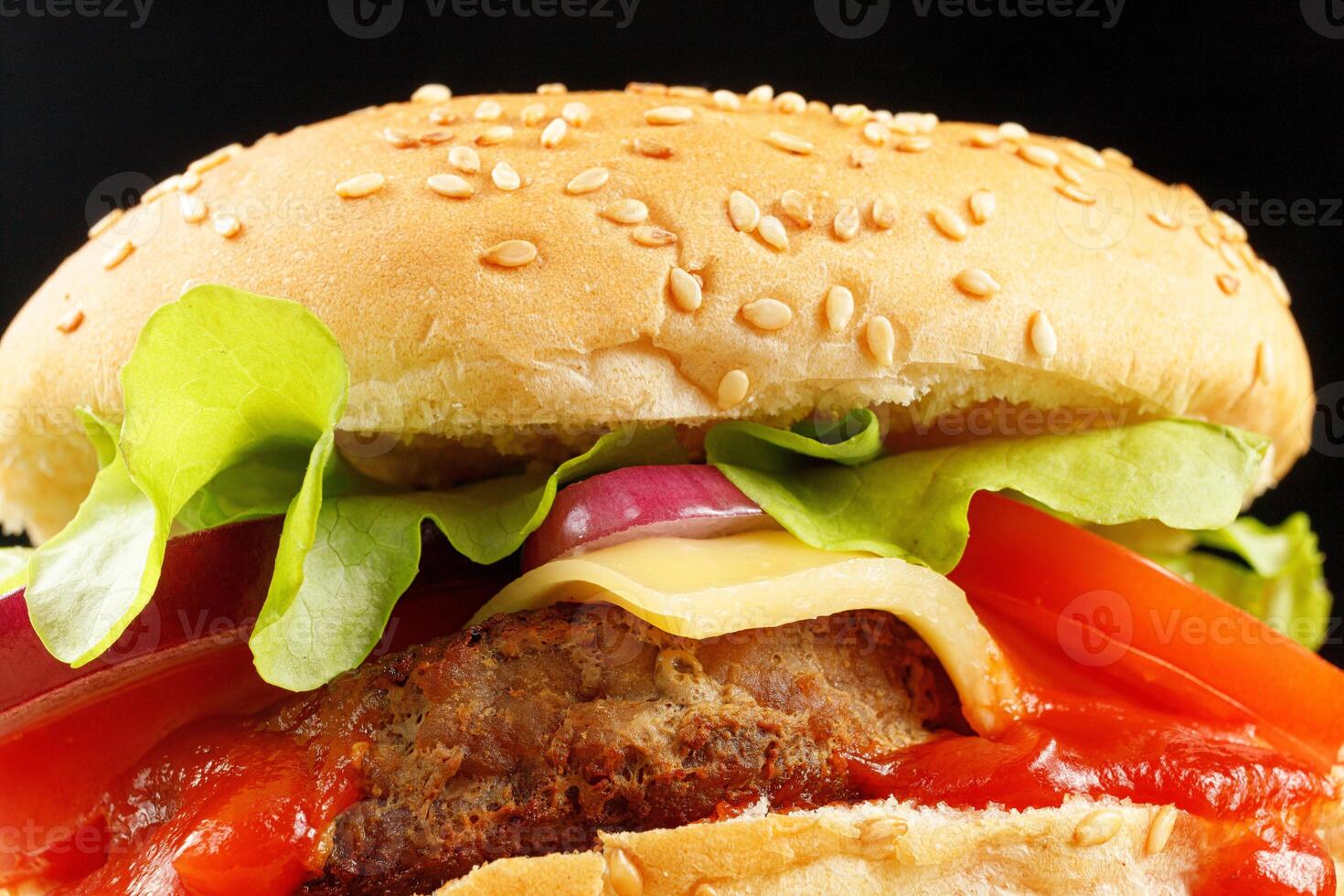 Tasty burger close-up. Burger with tomatoes, greens, onions and meat. Classic Burger close up photo
