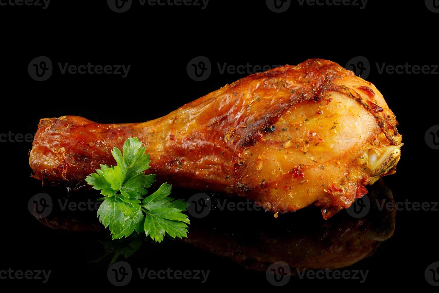 Fried chicken leg with greens on black. photo