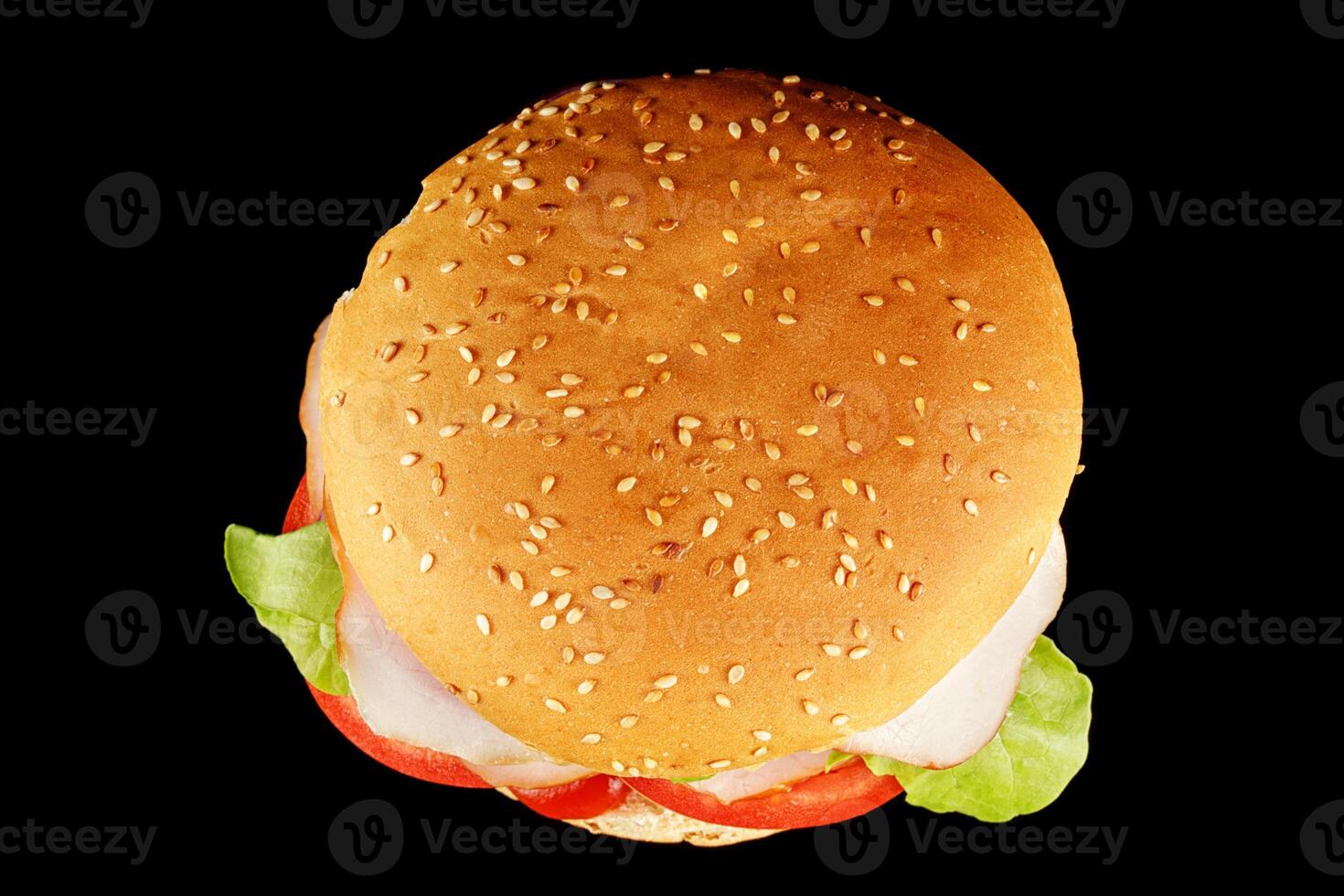 burger with lettuce, tomato, cheese and cutlet top view. Classic cheeseburger with beef, cheese, tomato on black background. Top view. photo