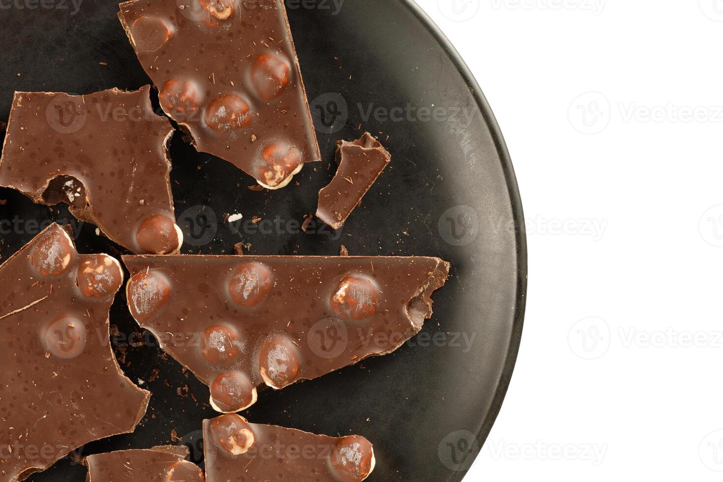 Pieces of chocolate with nuts in a black plate. place for text cope space photo