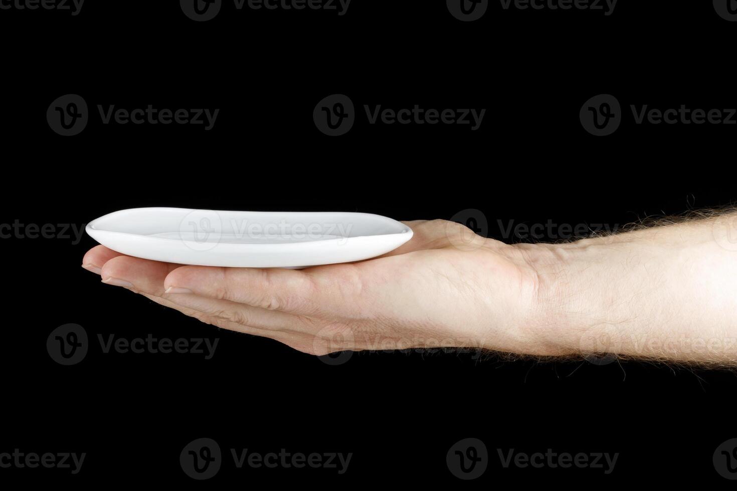 White saucer in hand of a Caucasian. photo