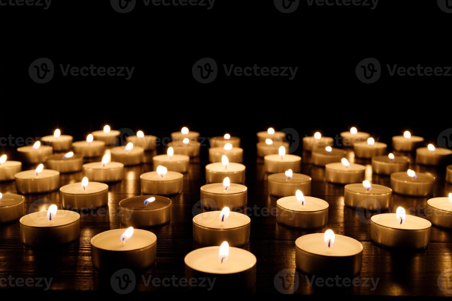 Many burning candles with shallow depth of field. Candles flicker in the dark photo