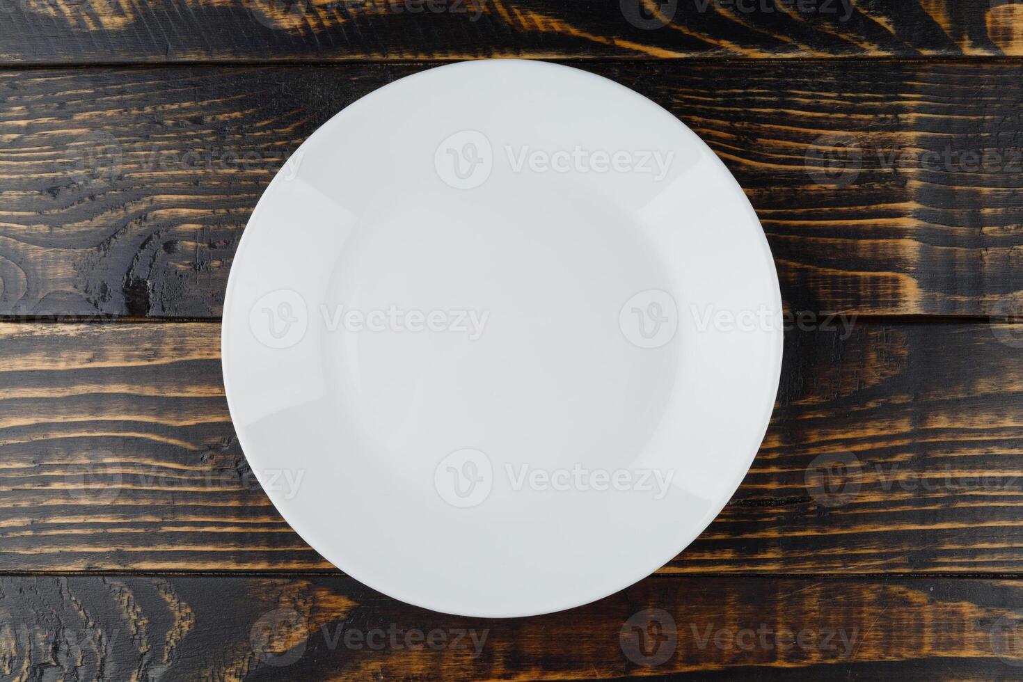 Empty white plate on wooden background photo