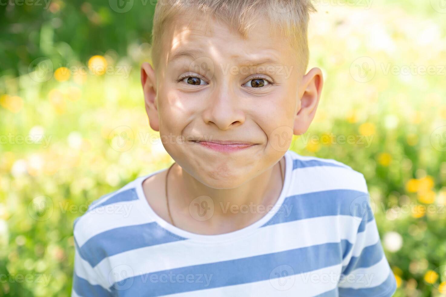 Portrait of a boy making a face in a summer park. Selective focus. photo