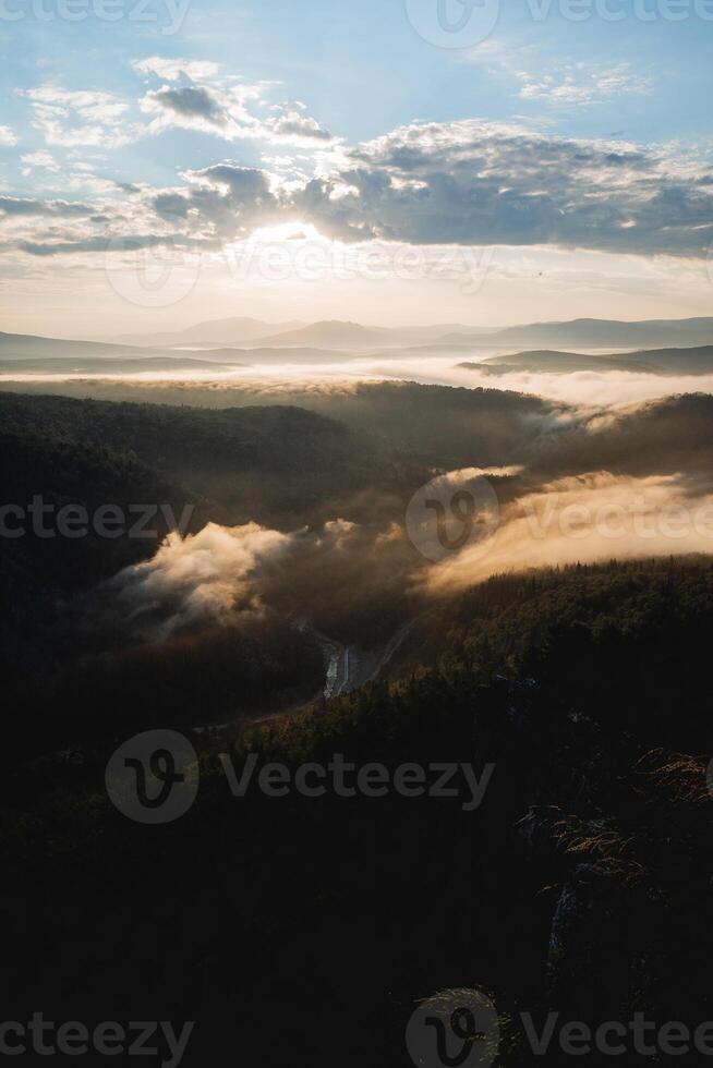 Sunrise in the mountains, Aigir view from the top of the mountain to the river valley, Bashkortostan nature of Russia, the Ural Mountains, fog in the morning creeps below. photo