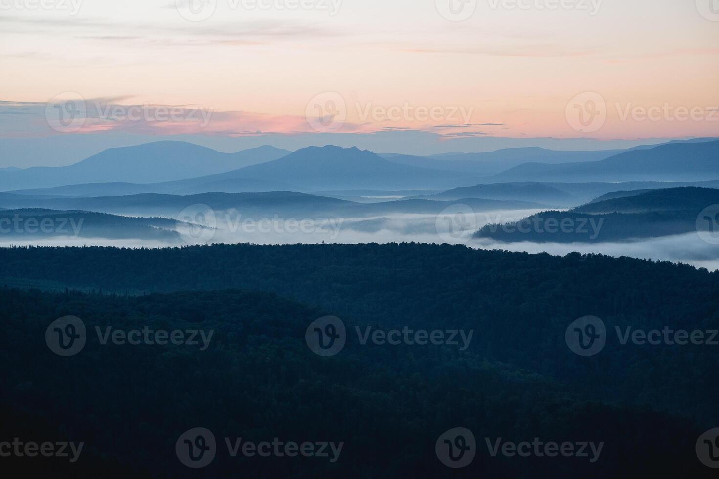 Morning in the mountains fog rises over the valley of the mountains, the first hour of dawn, a cold morning, smoke spreads below the river. photo