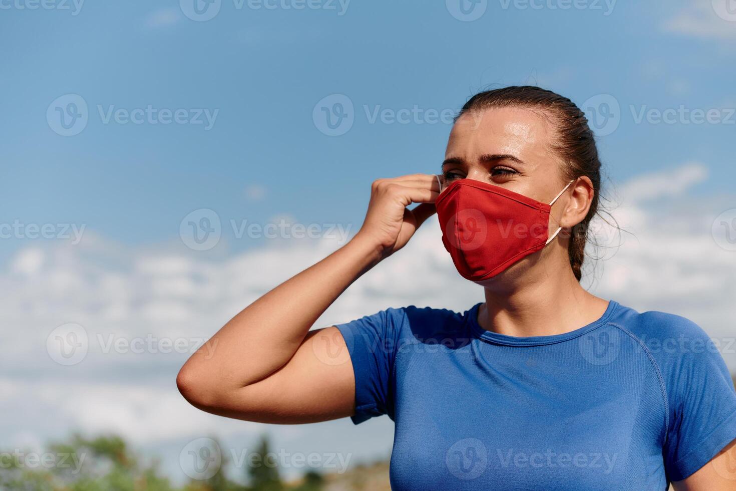 Athlete woman is getting ready to run with a mask on her face photo