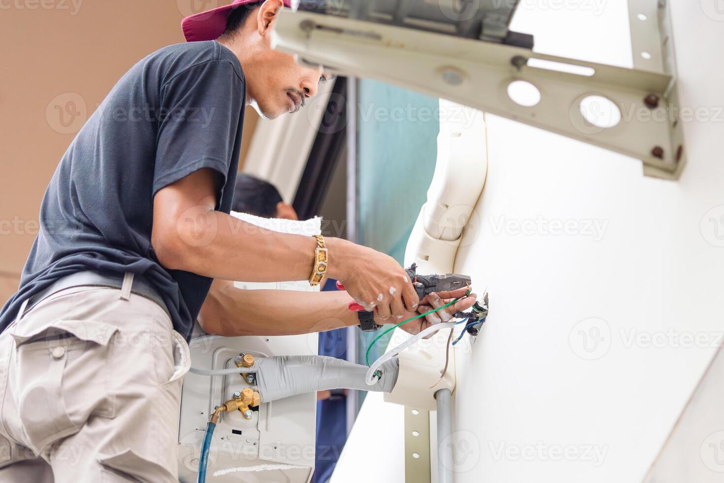 Technician connecting electric wires to install new air conditioning, Team repair service, and install new air conditioner concepts photo