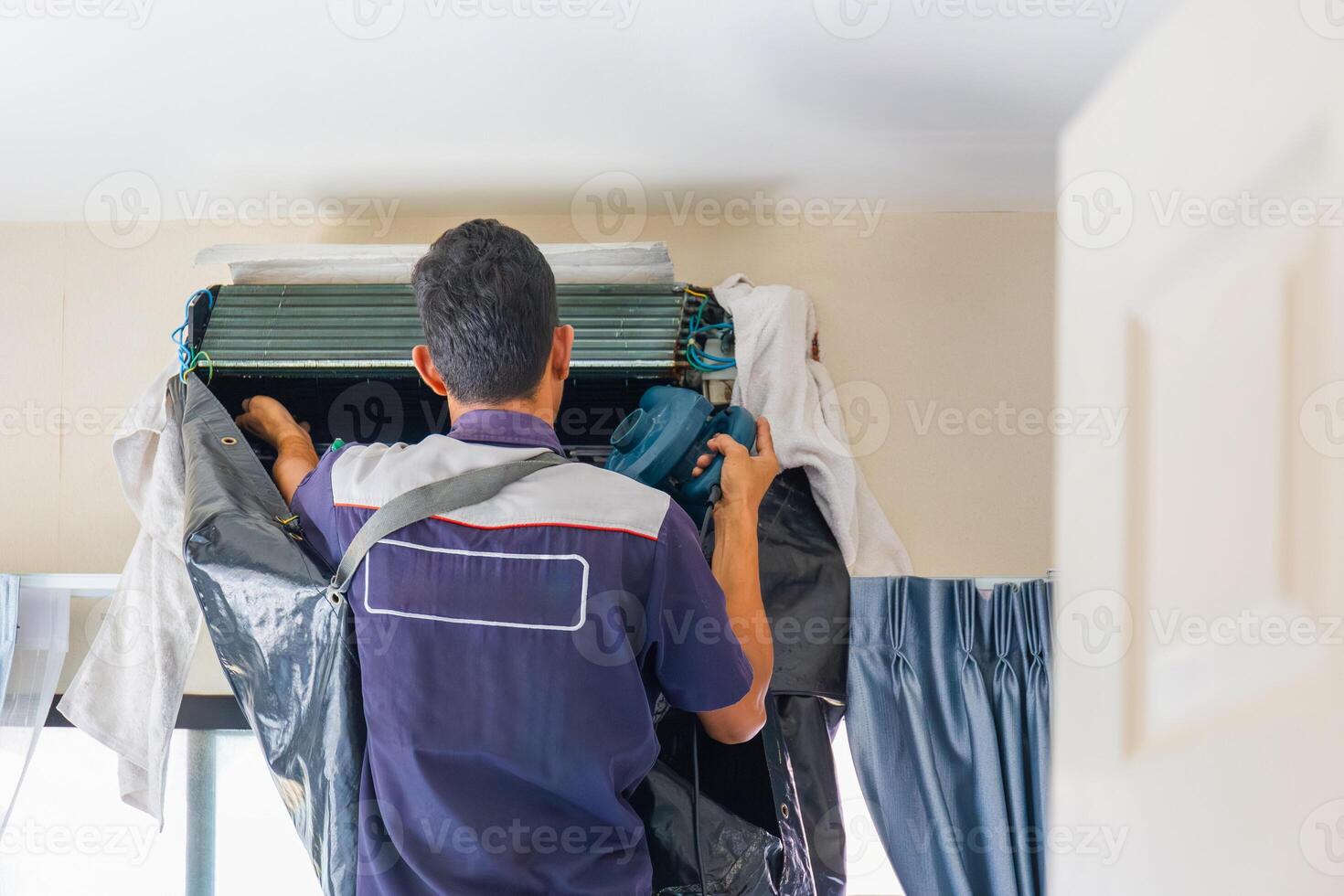 Repairman washing dirty inside the compartments air conditioner, Technician man clean air conditioning system, Maintenance and service concepts photo