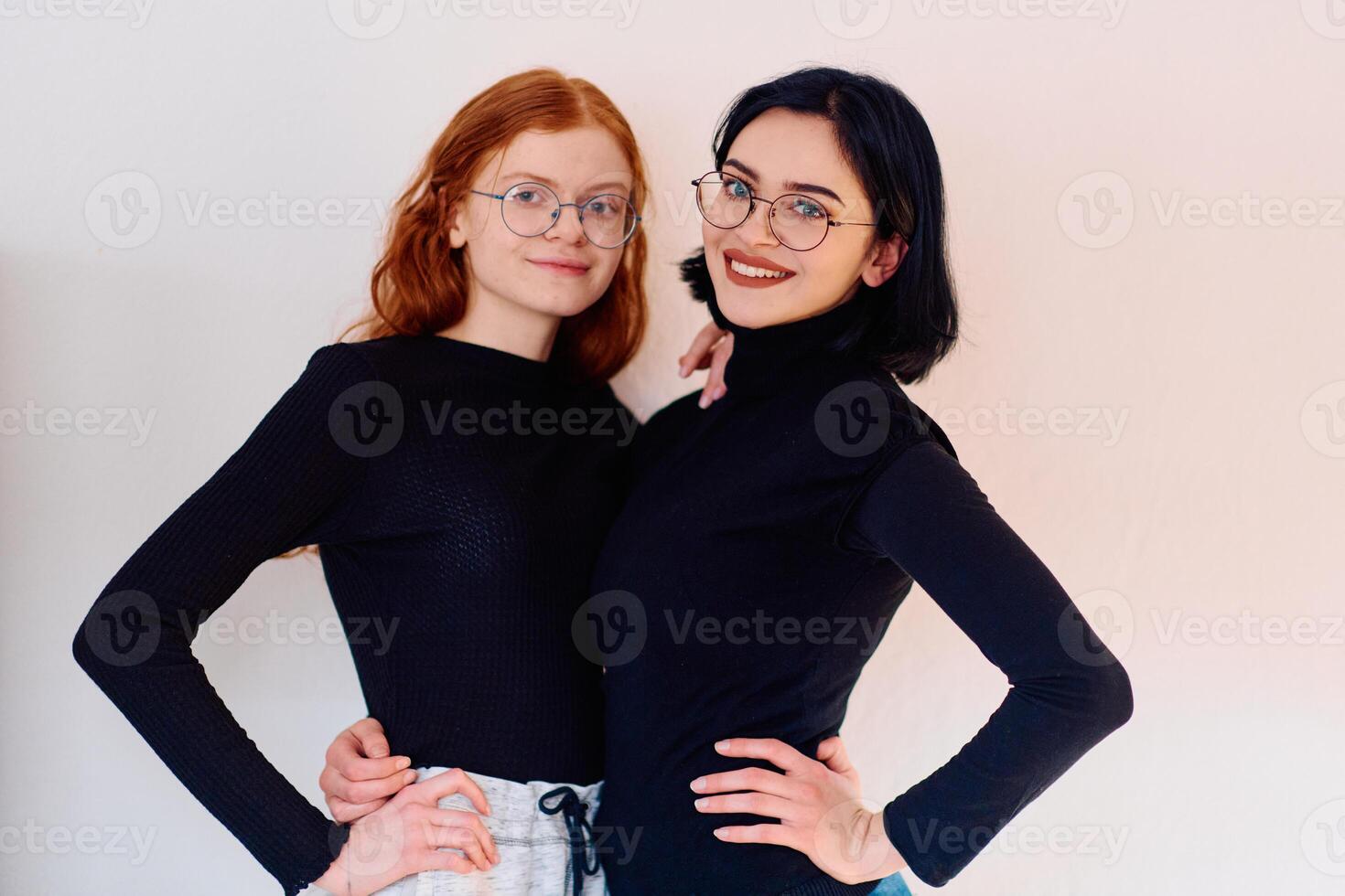 Sisterly Embrace. Portrait of Two Siblings, One Brunette and One Redhead, Against White Background photo
