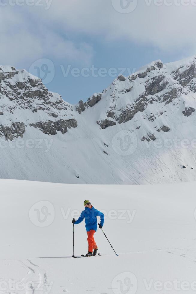 A Skier Scales a Treacherous Alpine Peak photo