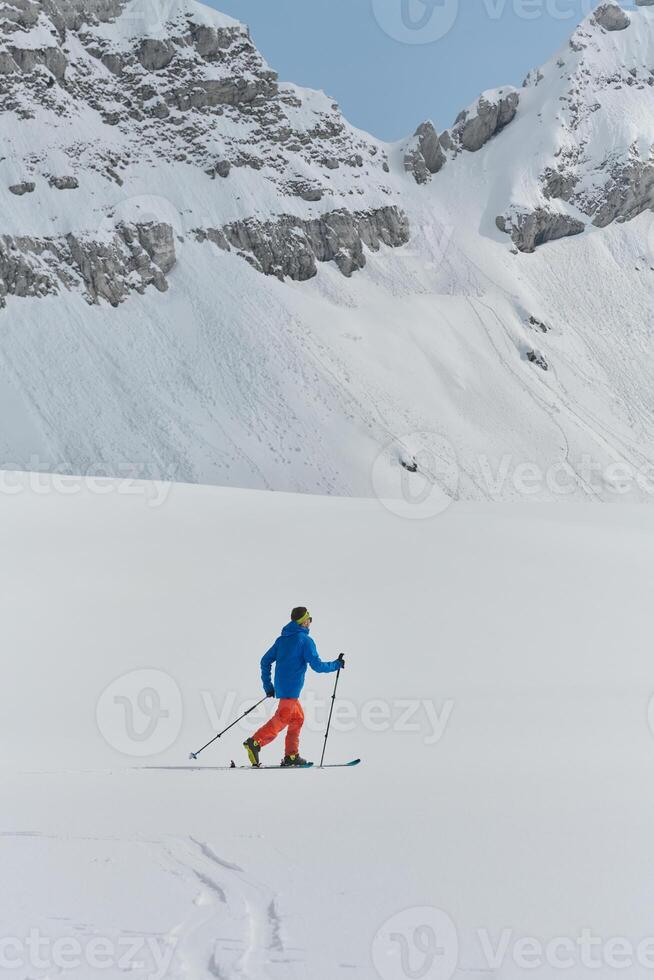 A Skier Scales a Treacherous Alpine Peak photo