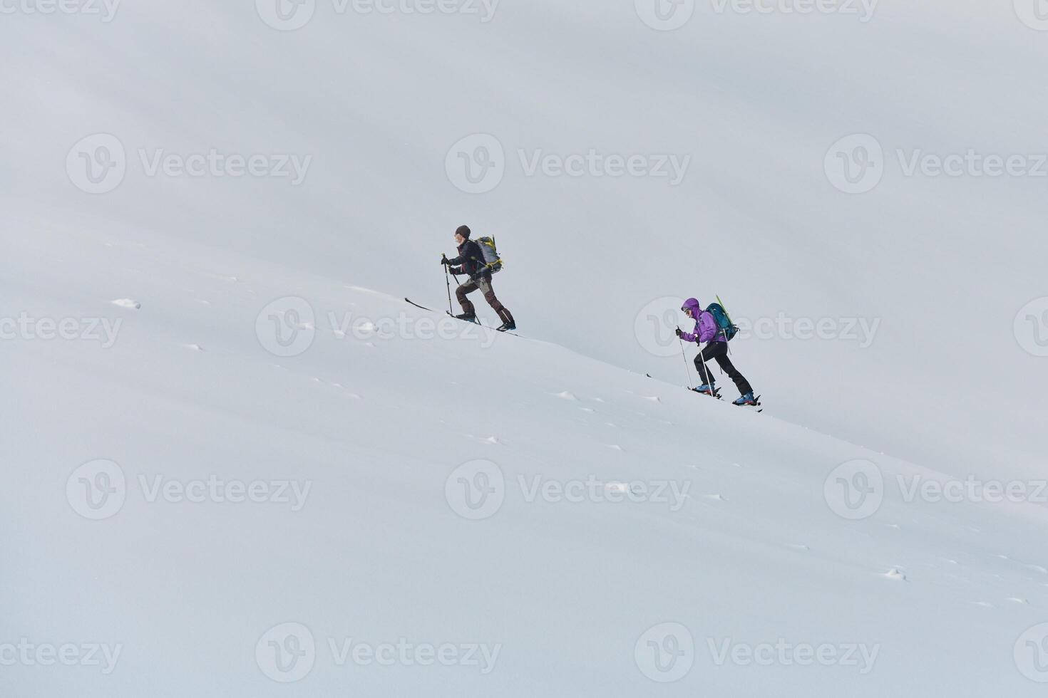 Alpine Ascent. Two Professional Skiers Conquer Snowy Peaks as a Determined Team. photo