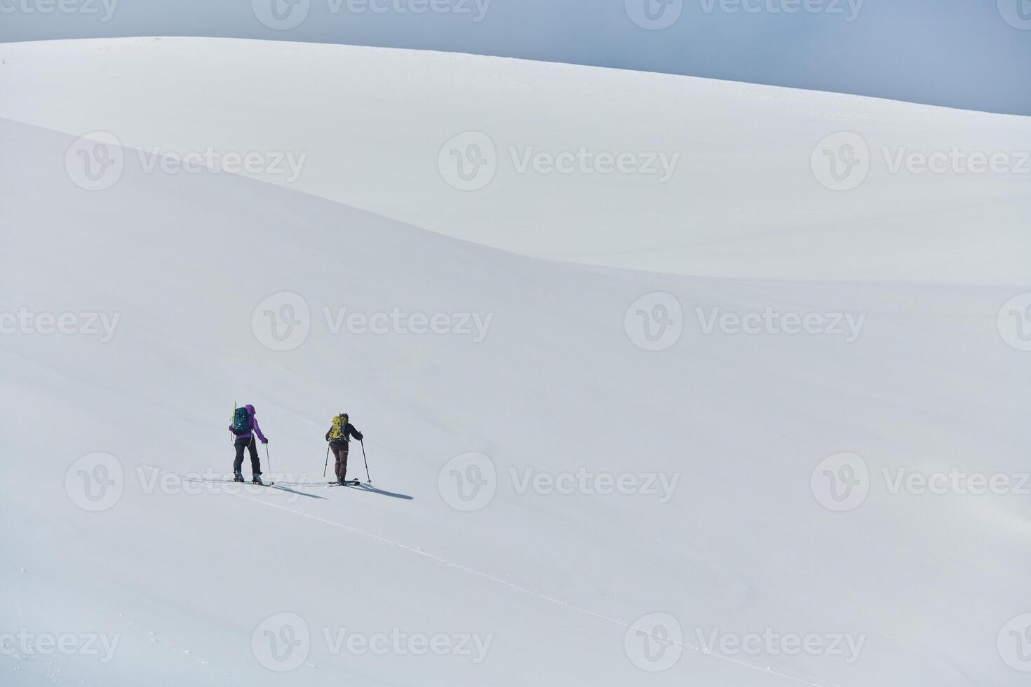 Alpine Ascent. Two Professional Skiers Conquer Snowy Peaks as a Determined Team. photo