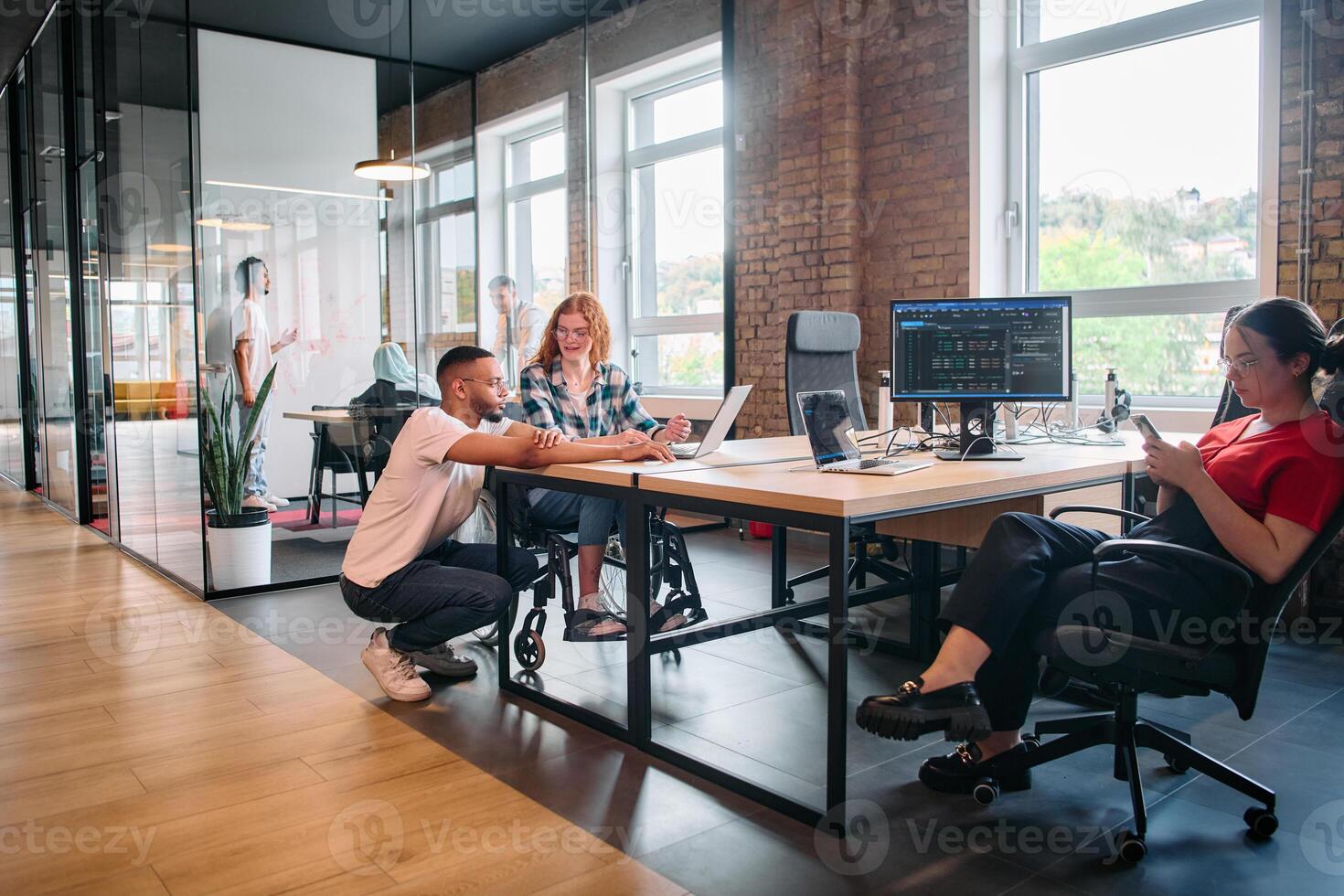 A diverse group of business professionals collaborates in a modern startup coworking center, utilizing a mix of paper-based and technological tools such as mobile phones and computers photo