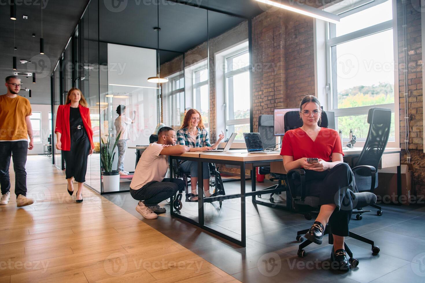 A diverse group of business professionals collaborates in a modern startup coworking center, utilizing a mix of paper-based and technological tools such as mobile phones and computers photo
