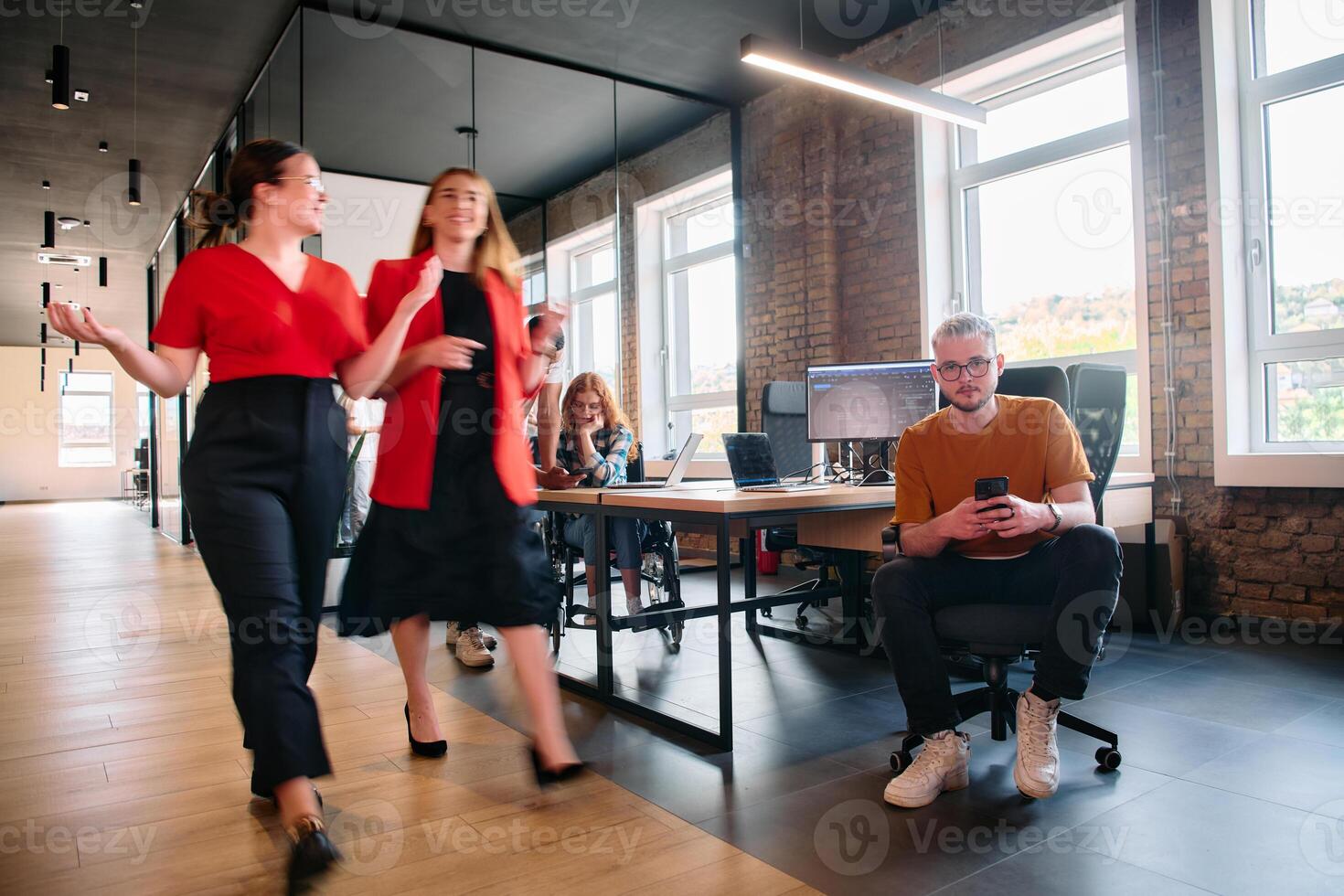A diverse group of business professionals collaborates in a modern startup coworking center, utilizing a mix of paper-based and technological tools such as mobile phones and computers photo