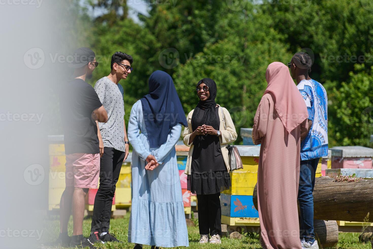 A diverse group of young friends and entrepreneurs explore small honey production businesses in the natural setting of the countryside. photo