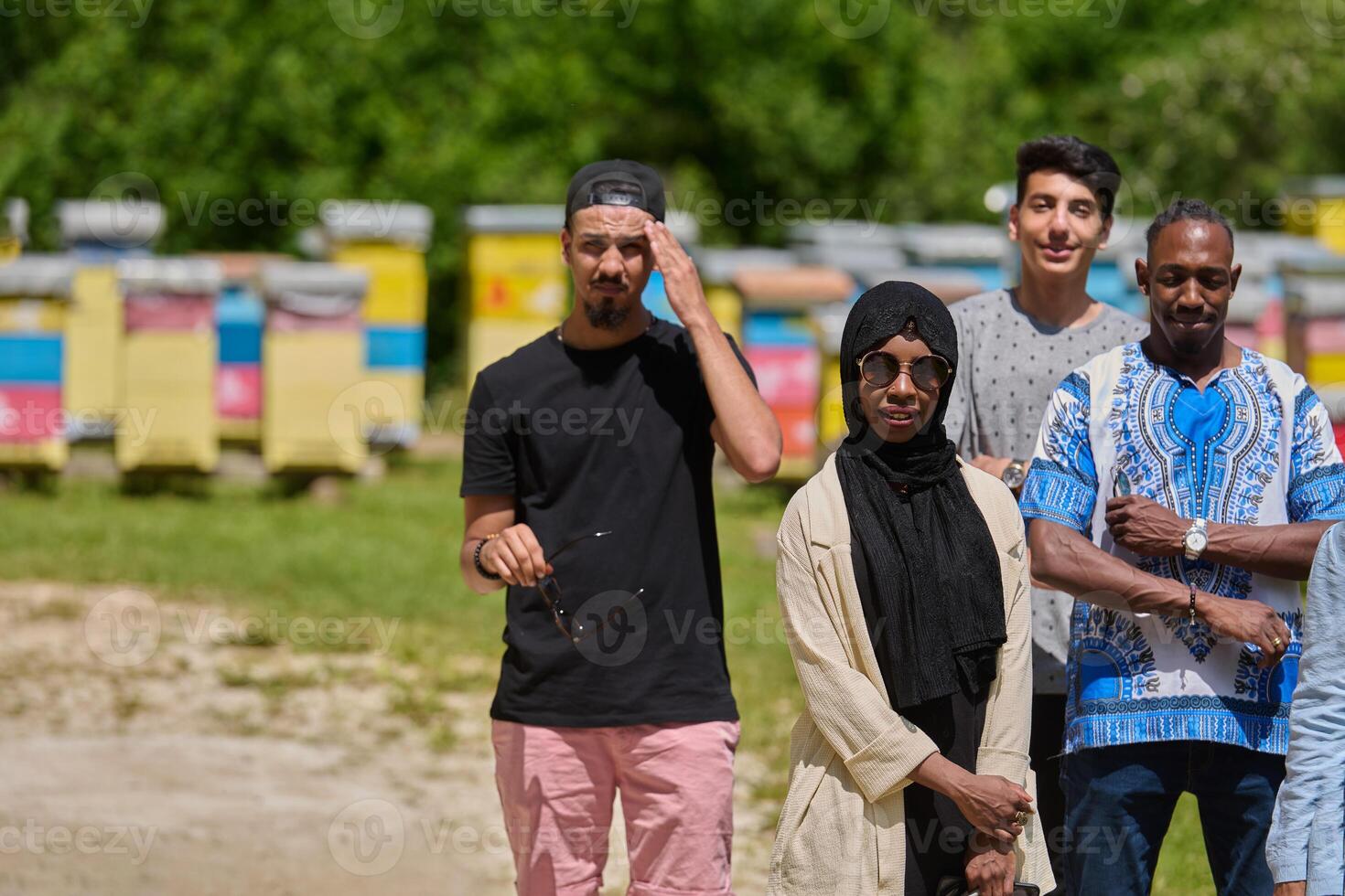 A diverse group of young friends and entrepreneurs explore small honey production businesses in the natural setting of the countryside. photo