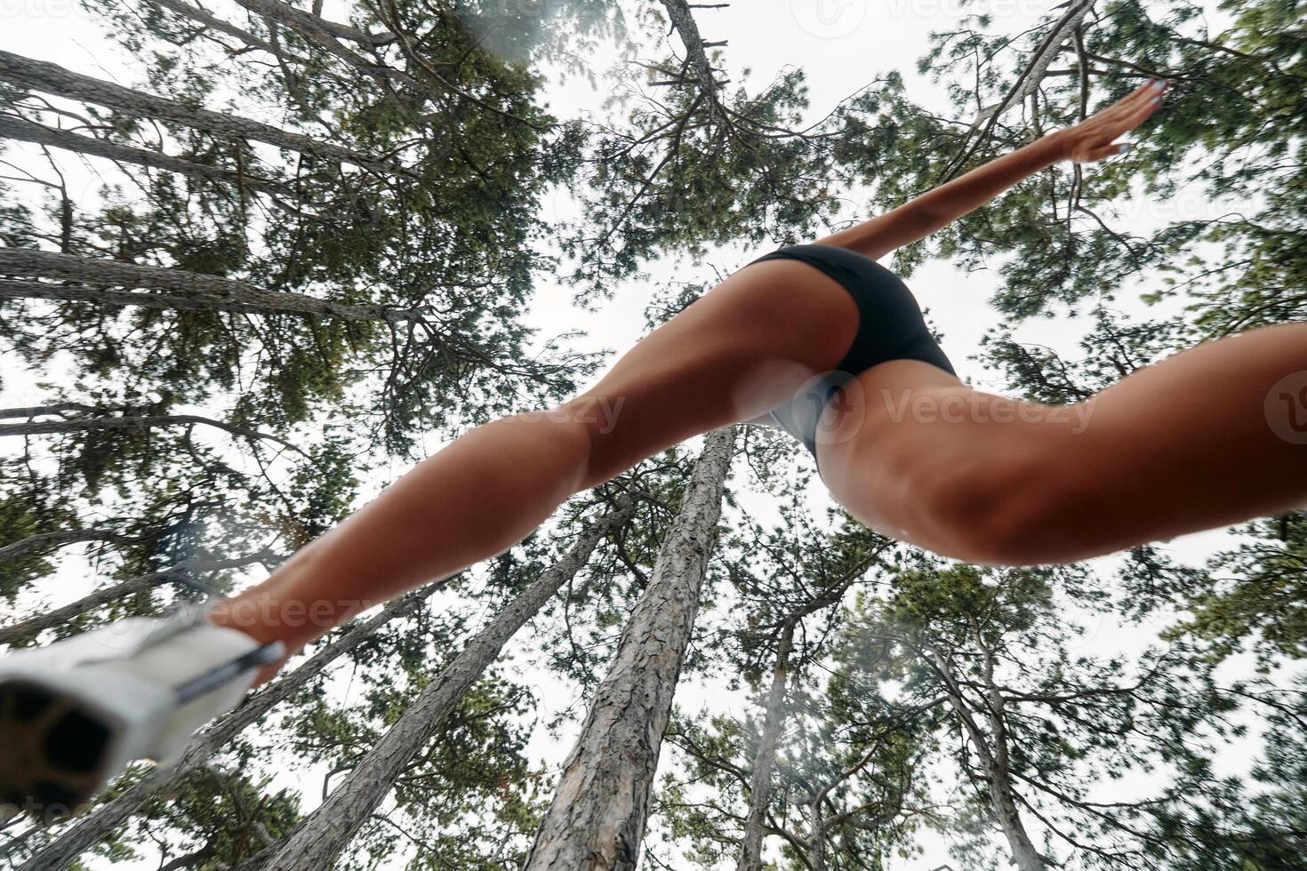 Adventurous Woman Overcoming Forest Obstacles with Determination and Agility. photo