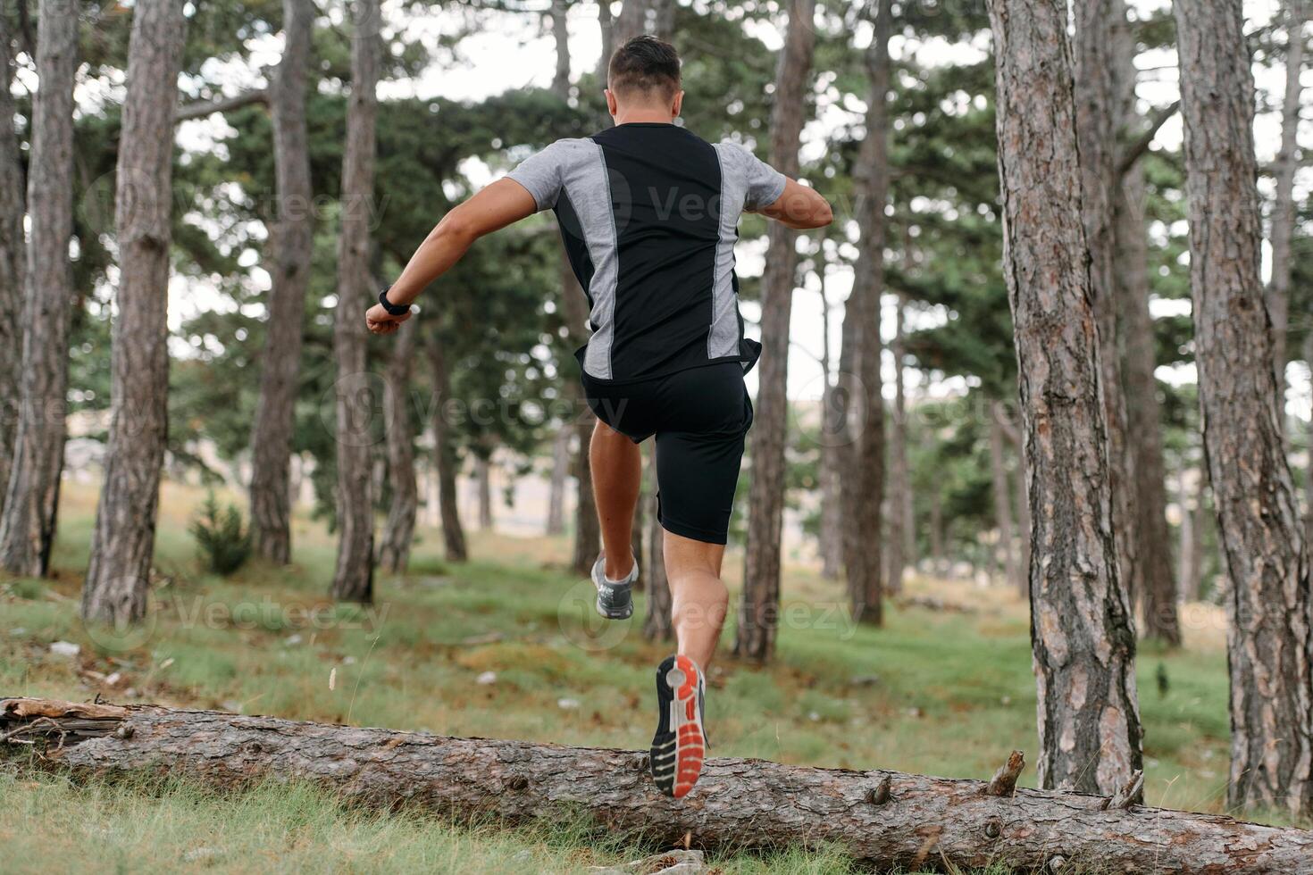 Determined Man Conquering Forest Obstacles with Grit and Speed photo