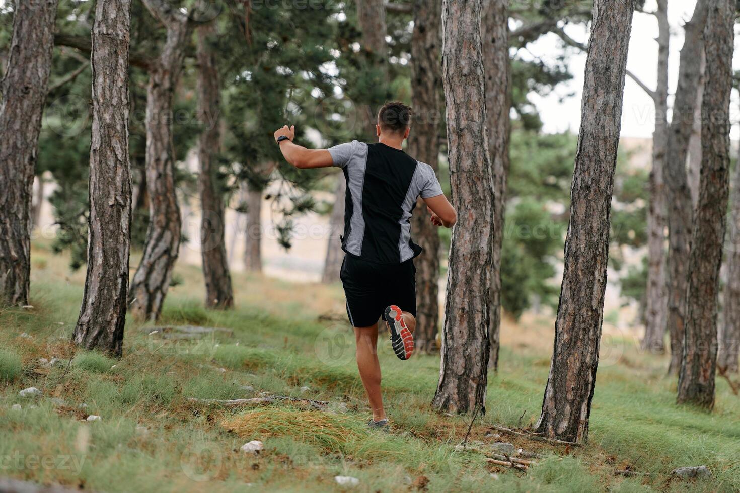 Determined Man Conquering Forest Obstacles with Grit and Speed photo