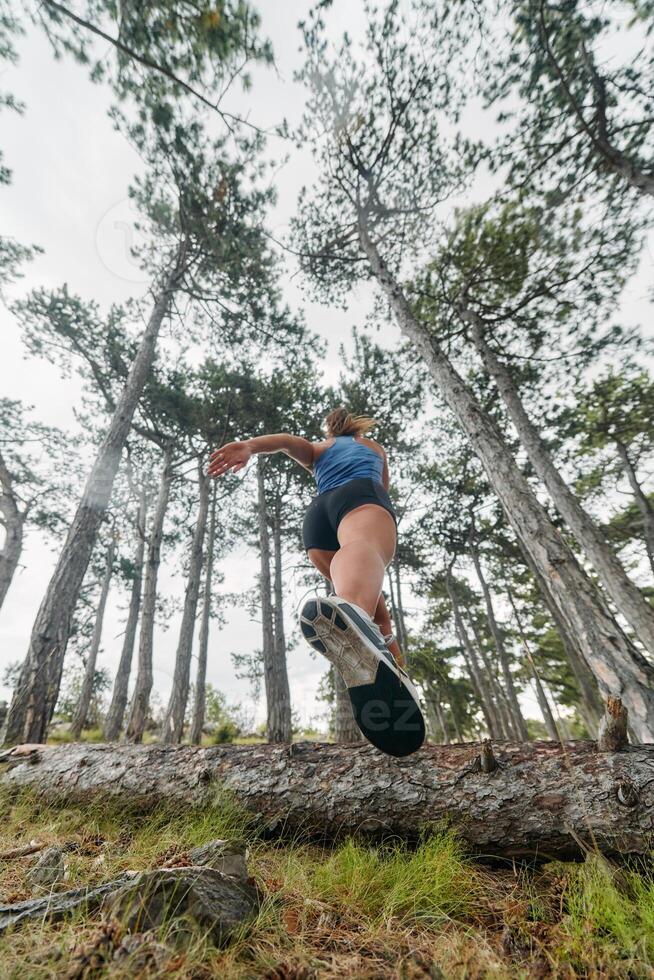 Adventurous Woman Overcoming Forest Obstacles with Determination and Agility. photo