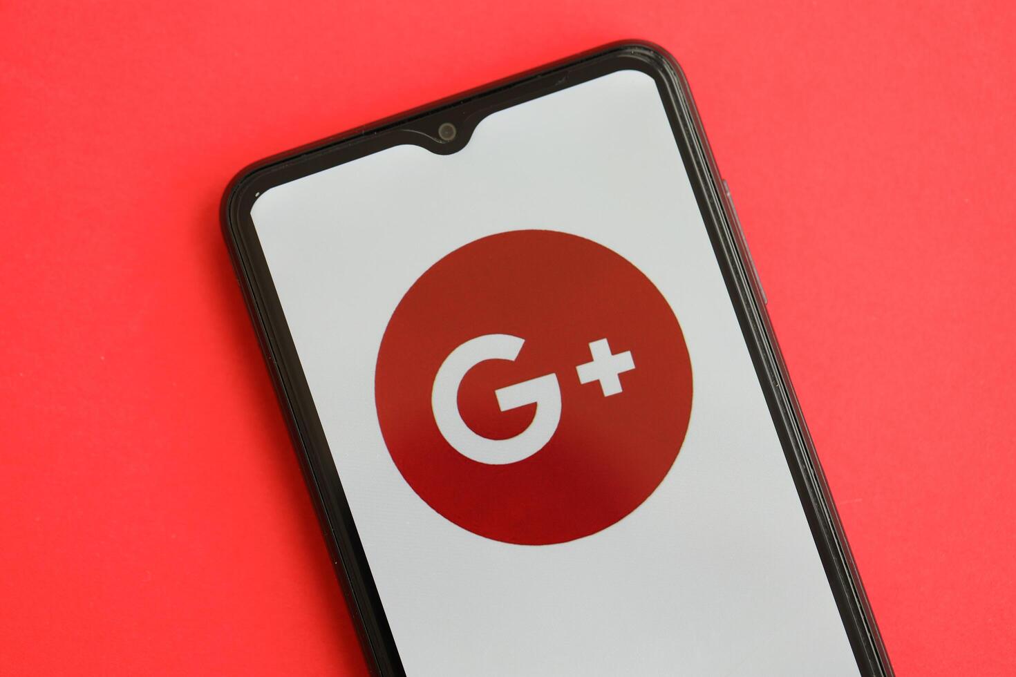 KYIV, UKRAINE - APRIL 1, 2024 Google Plus icon on smartphone screen on red table photo