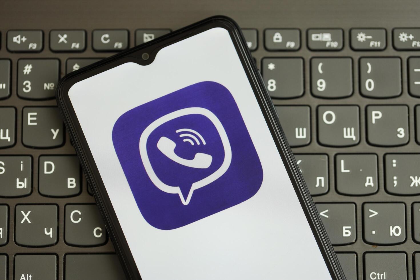 KYIV, UKRAINE - APRIL 1, 2024 Viber messenger icon on smartphone screen on black keyboard photo