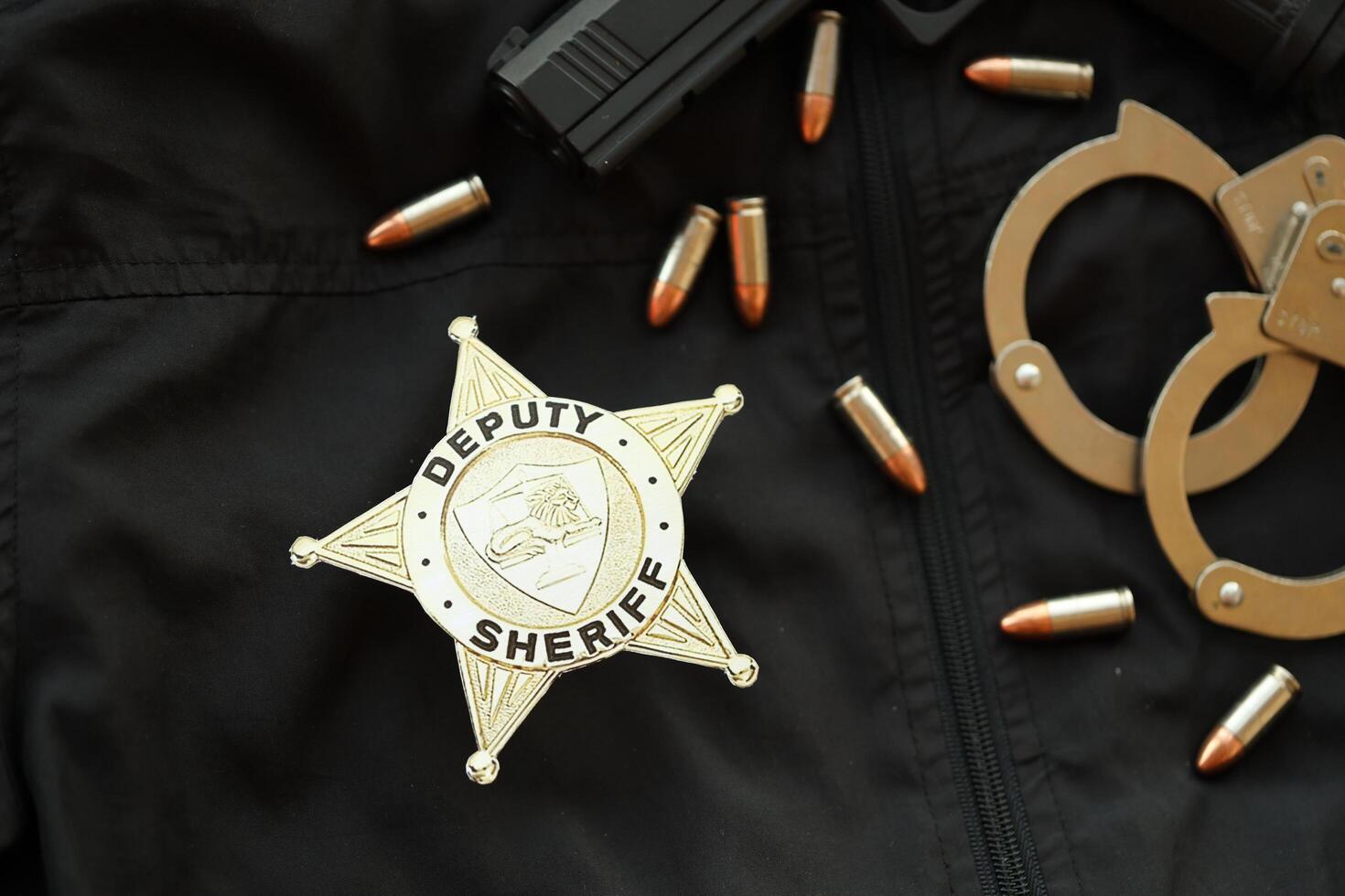 KYIV, UKRAINE - MARCH 9, 2024 US Deputy Sheriff badge on black jacket uniform with gun, bullets and handcuffs photo