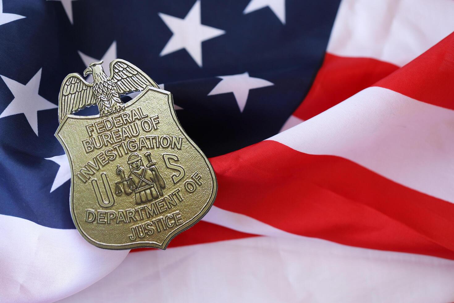 KYIV, UKRAINE - MARCH 9, 2024 US FBI Federal Bureau of Investigation badge on United States of America flag photo