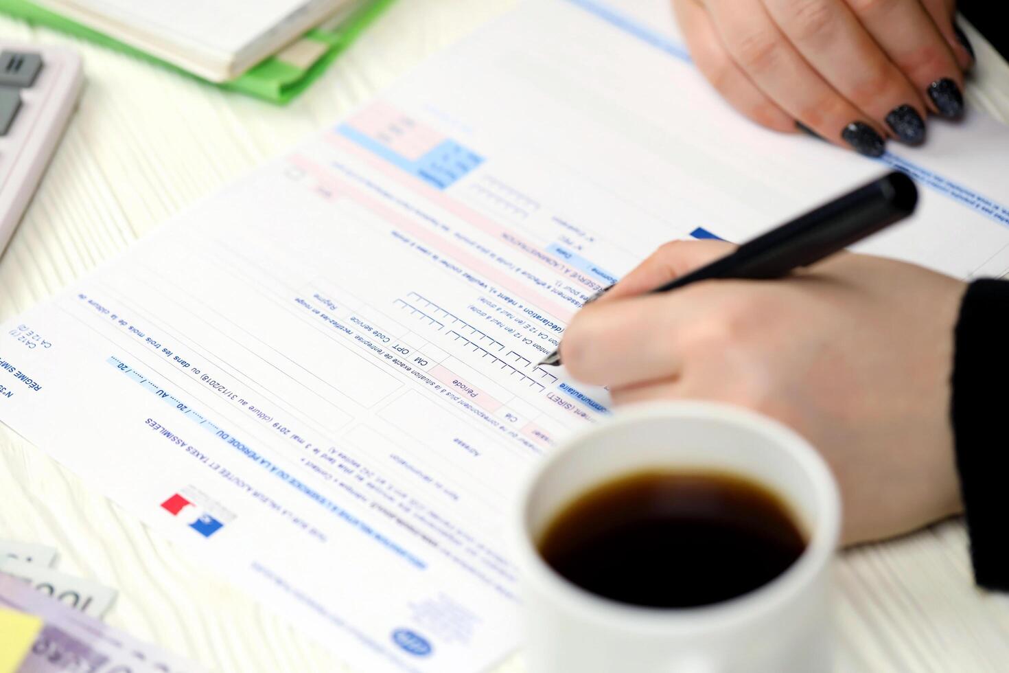 KYIV, UKRAINE - OCTOBER 31, 2023 Accountant fill french tax form CA12 Value added tax and similar taxes in end of tax period. Taxation and paperwork routine photo