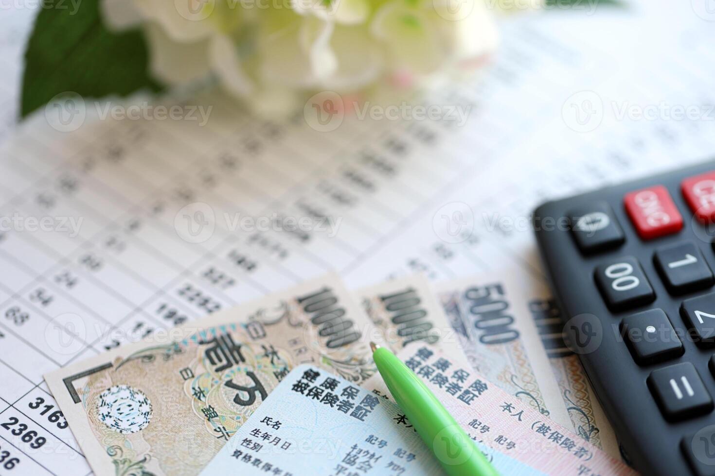 Light blue and red Japan Health Insurance cards on table with japanese yen money and calculator photo