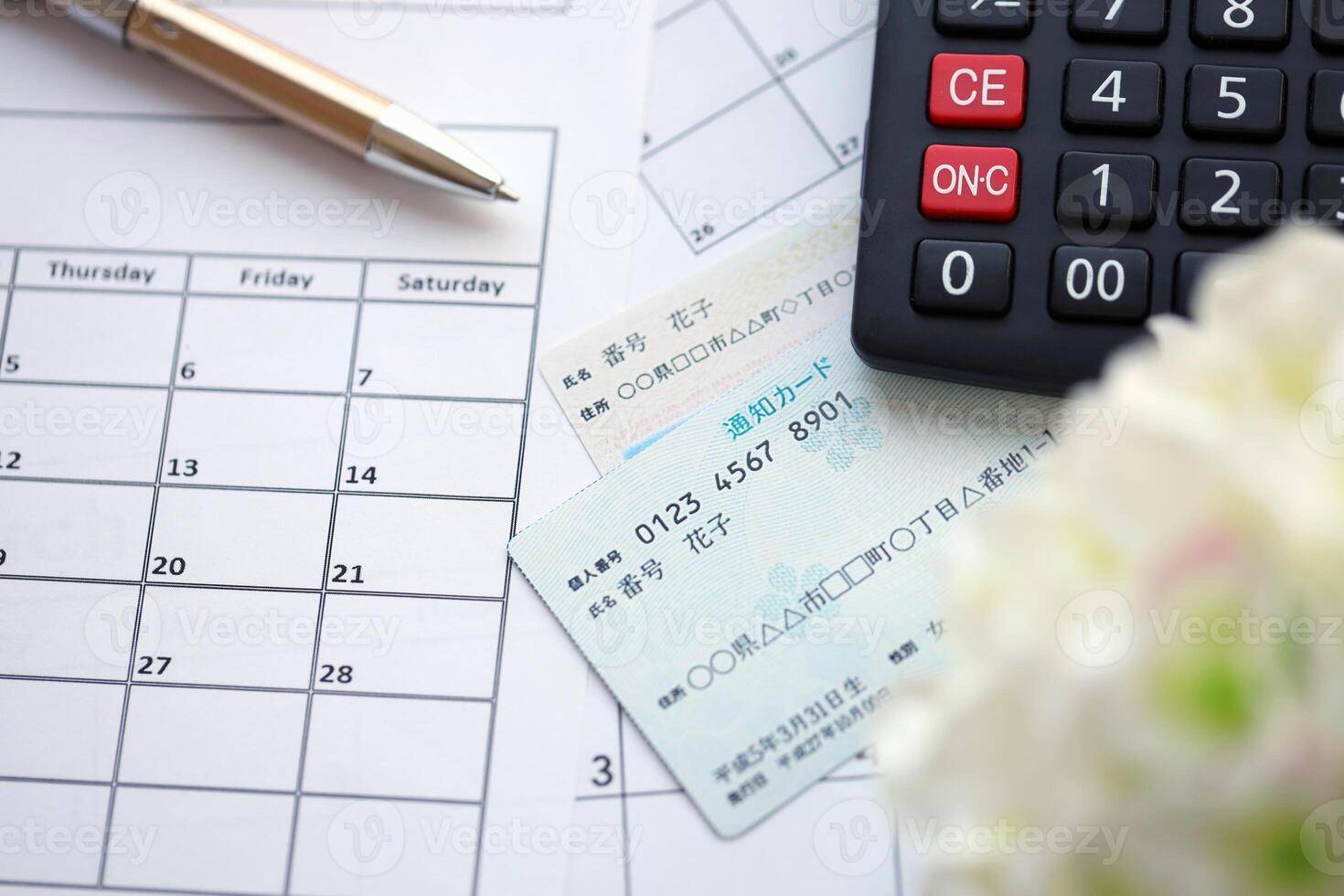 Japanese my number card specimen and notification card on calendar background with calculator photo