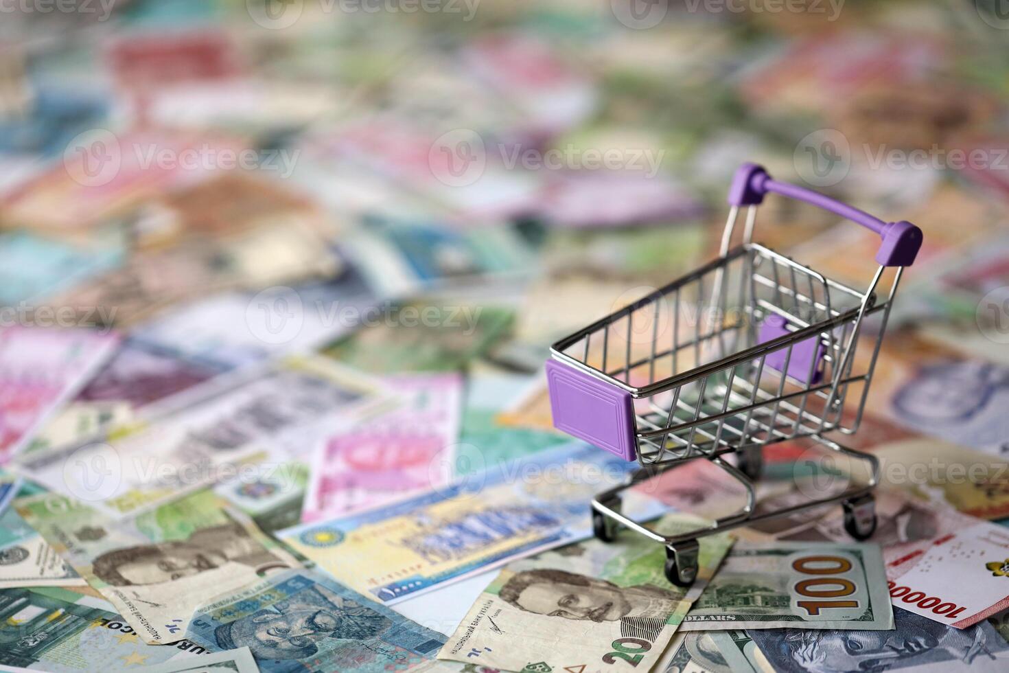 Supermarket trolley on many banknotes of different currency. Background of shopping worldwide photo