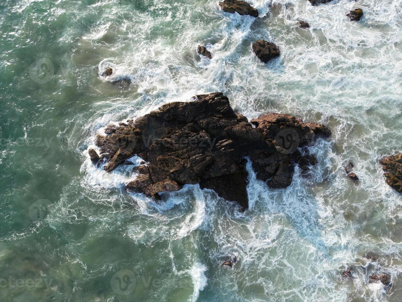 Aerial View of Rugged Coastal Rocks Bathed in Foamy Waves in Mazunte, Mexico photo