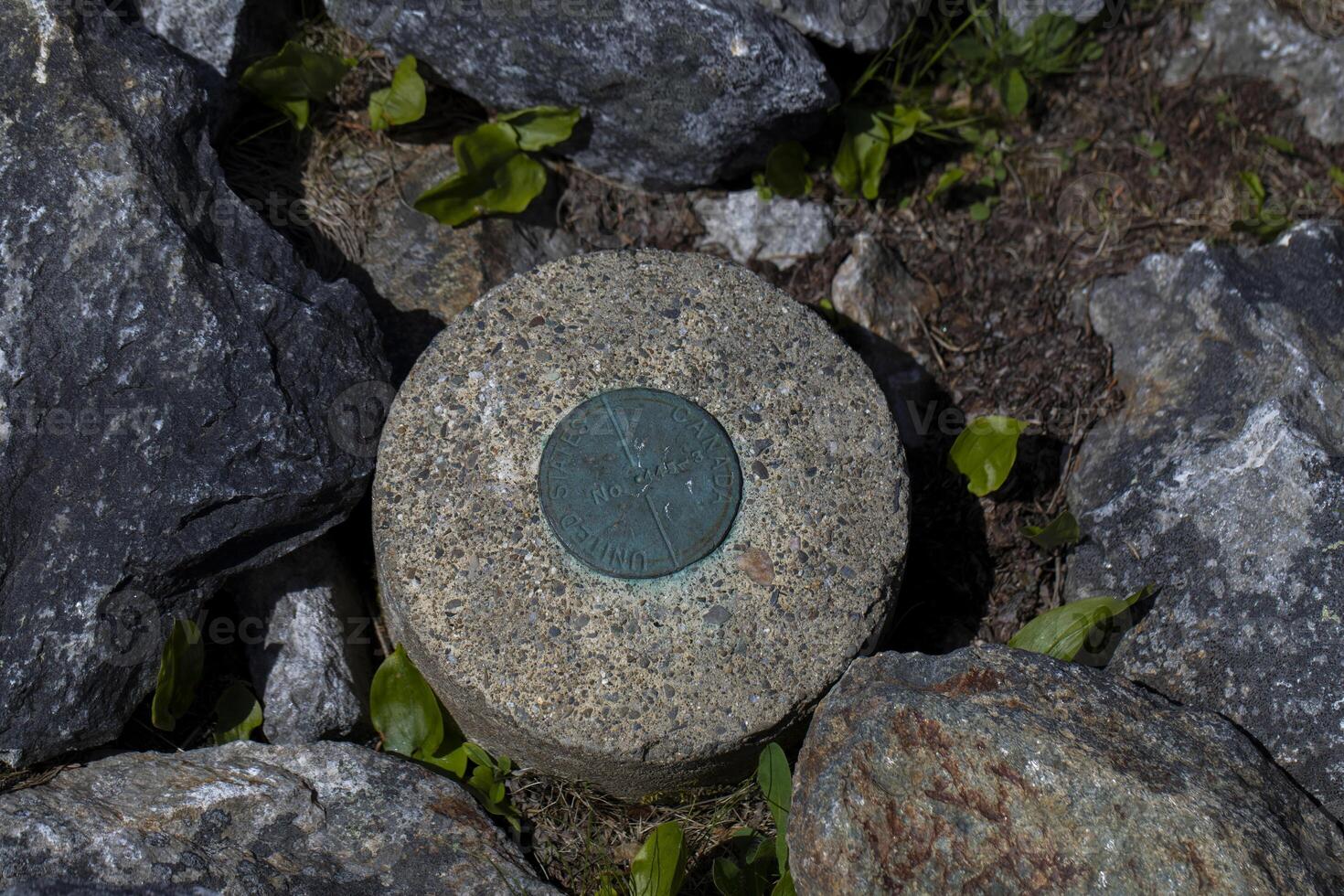 A Survey Marker Embedded in Rocks on a Mountain Trail photo