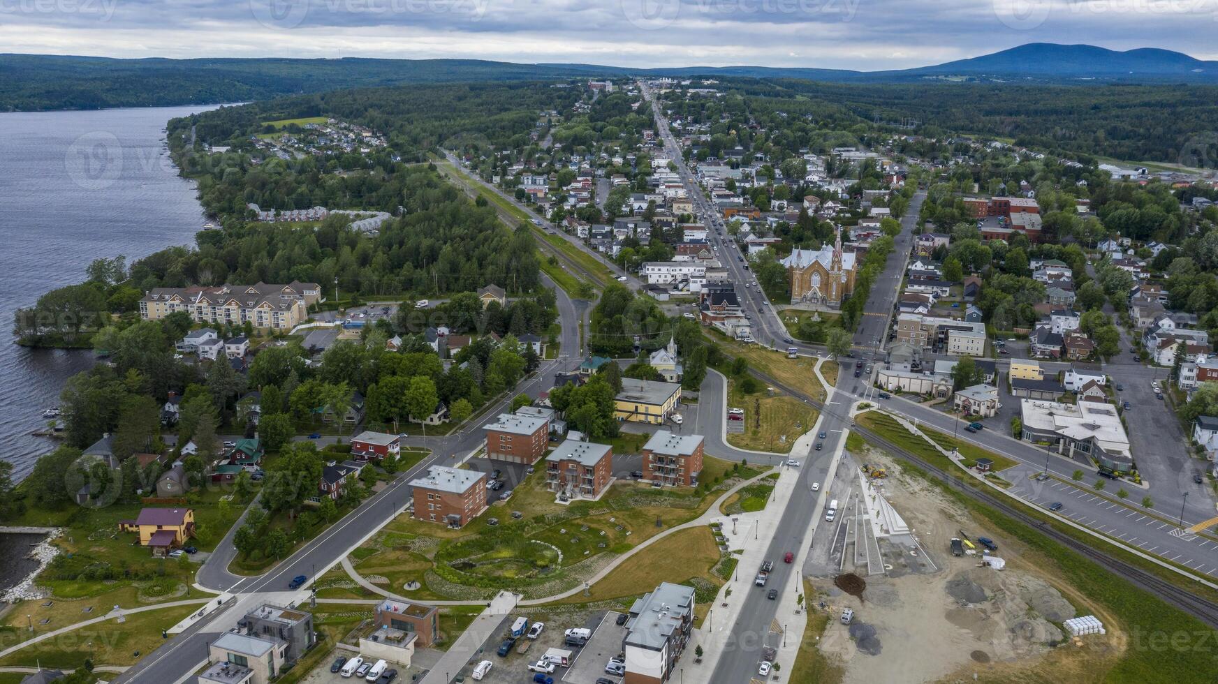 Aerial View of a Cityscape With a Lake and Mountains in the Background on a Cloudy Day, in Lac-Megantic, Quebec, Canada photo