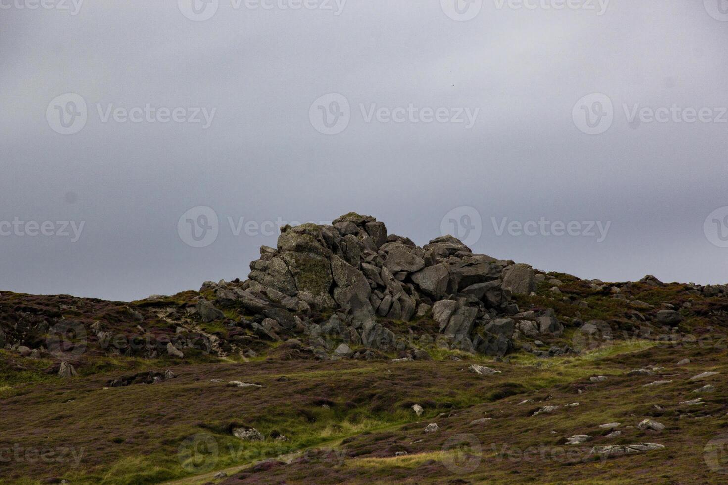 A Rocky Outcropping on the Irish Coast Under a Cloudy Sky photo