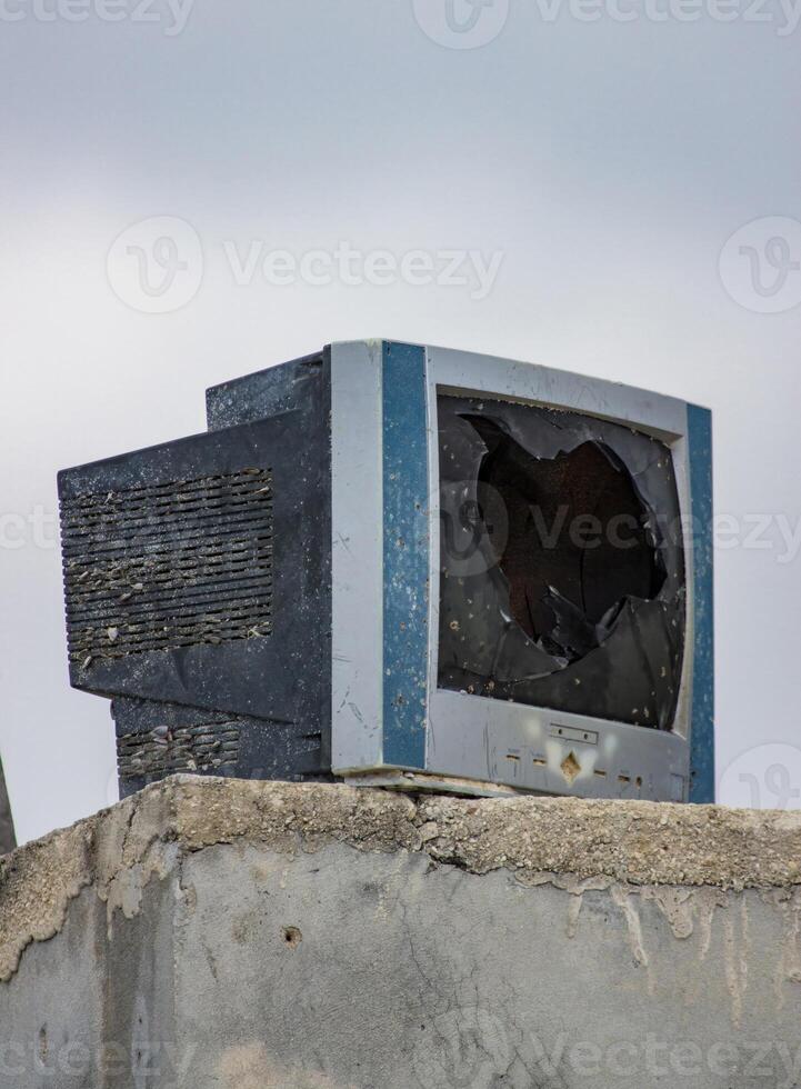 A Broken Television Abandoned on a Concrete Wall photo